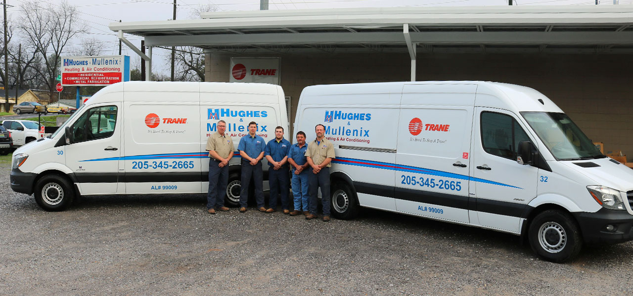 Hughes & Mullenix employees in front of vans